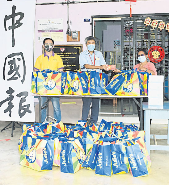 欧盛财（中）代表《中国报》和Julie's饼干生产商，移交慈爱人间红包和物资给英达花园特殊儿童康复中心，由比查莉（右）代表接领。