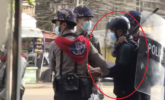 登佐(红圈)2月27日在仰光报导民众示威活动时被3警员围捕的情况。