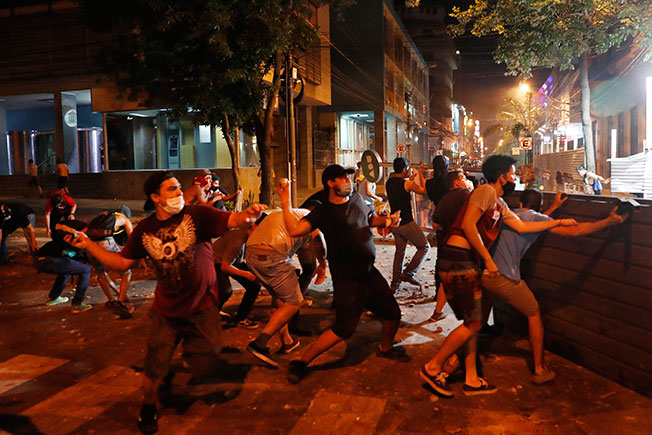 巴拉圭抗议民众向警察丢掷石块。（美联社）