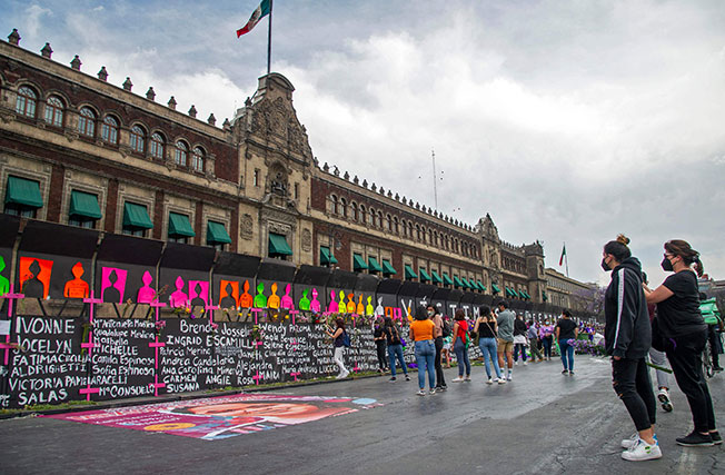 墨西哥女性周日走上街头，要求当局给被杀害和失踪的女性伸张正义。位于首都墨西哥城的国家宫外，可见设起一道长长的围栏，上面写满被杀害和失踪的女性名字，民众向前献花哀悼。（美联／法新社）