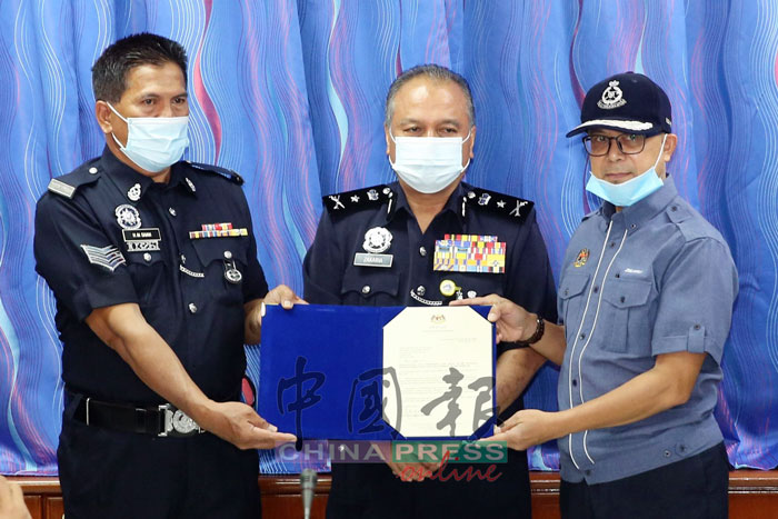 祖基菲里（右起）在仄查卡里亚见证下，将表扬状颁赠给末沙卡欣，表扬他英勇事迹。