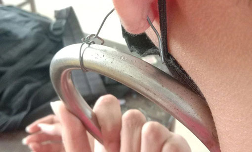 泰国中学男生违规穿耳洞，老师拿金属环用铁丝吊在他的耳垂上。