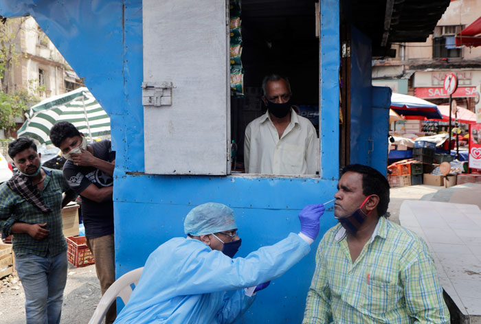 孟买一名医护人员上周四给一名劳工进行新冠肺炎拭子检测。（美联社）