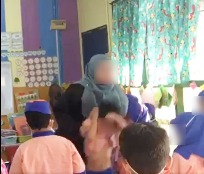 女教师抓起学生后，把学生扔向前方。