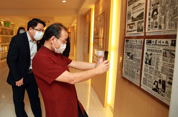欧阳玉靖参观历史轩时，拿出手机拍下中国领袖报导的剪报。