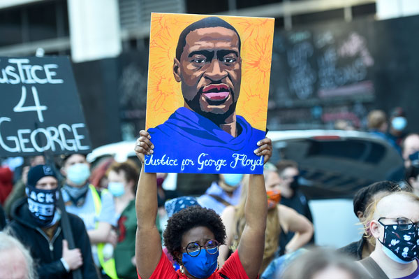 民众周一举着弗洛伊德的画像，在明尼阿波利斯街区游行。（欧新社）