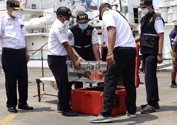 印尼国家运输安全委员会正搬运含有驾驶舱语音记录器的箱子。（美联社）