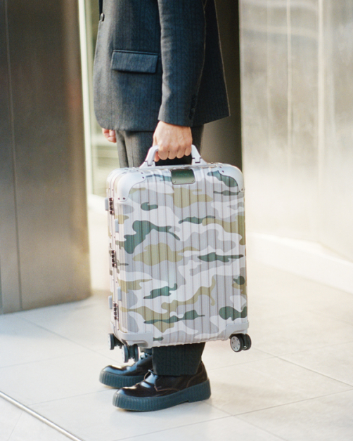 Rimowa Original Camouflage行李箱将颜料融入铝镁合金极氧化技术中，形成持久的金属光泽，阳光照射下，映照出3种不同色彩，完美贴合行李箱的形状和结构，看起来又似漂浮于箱面上，十分奇幻。