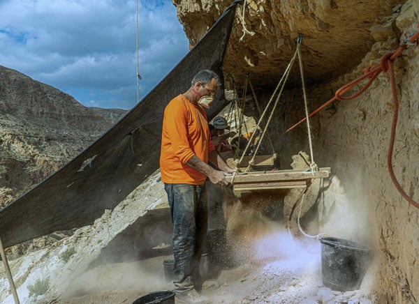 考古学家在犹大沙漠一个洞穴入口筛土 。（法新社）
