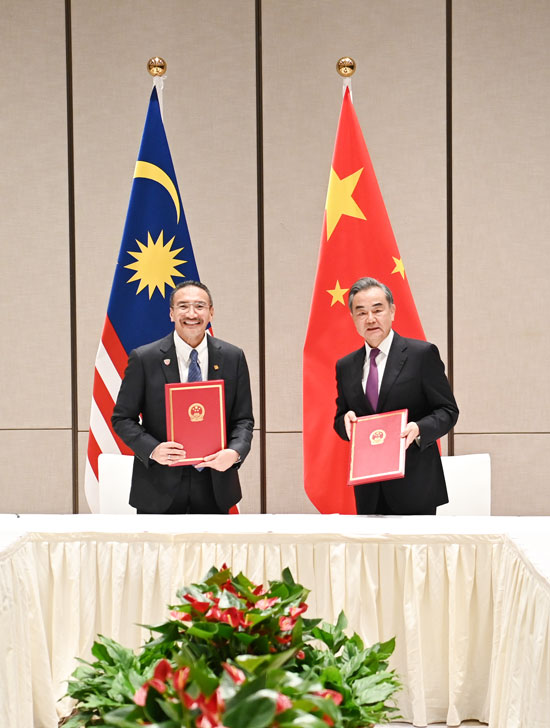希山慕丁（左起）和王毅在会谈后，共同签署《中国政府和马来西亚政府关于建立中马合作高级别委员会推进后疫情时期合作谅解备忘录》并合影。