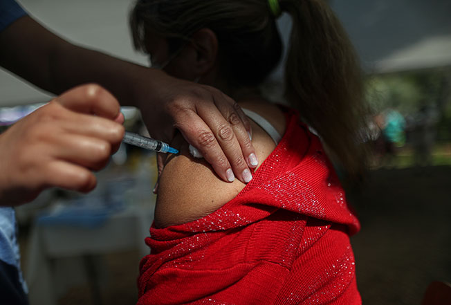圣地亚哥医护人员正给一名女子接种辉瑞疫苗。（美联社）
