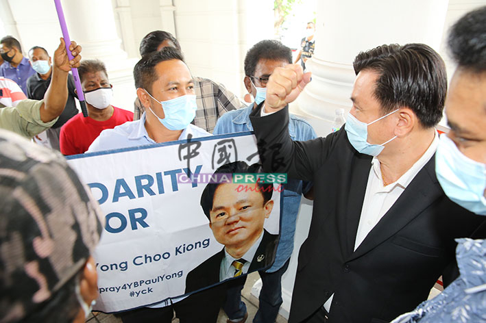 杨祖强（右）向支持者做出加油手势。