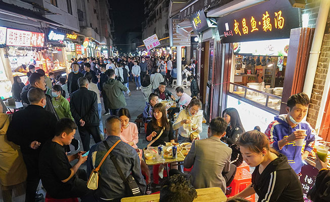 自2020年4月8日武汉“解封”，至今一年过去了，夜幕下的武汉，各个角落都焕发着活力，人们逛街吃饭休闲，感受城市夜生活的魅力。（新华社）