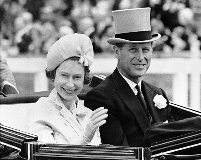 英女王自即位以来，从未缺席过一年一度的英国皇家赛马会；图为1962年，年轻的菲利普亲王陪伴伊丽莎白女王在比赛开始前进场。（美联社）