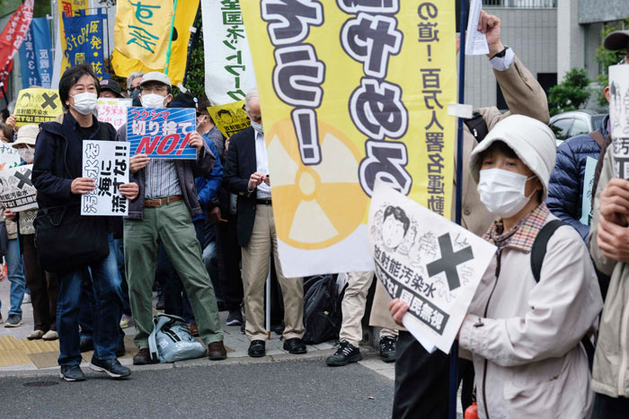 日本民众周二在东京首相府外举标语牌，抗议政府把核污水排入大海的决定。（法新社）