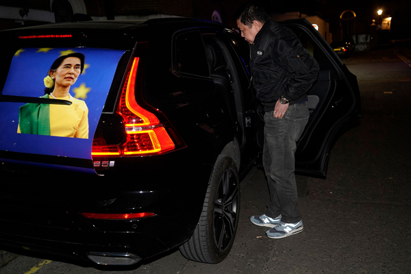 大使馆门外的一辆车子后镜张贴了翁桑苏姬的海报。（法新社）