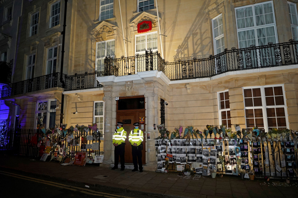 大使馆门外有警察驻守；周遭的鲜花是祭奠照片中被缅军枪杀的无辜民众。（法新社）