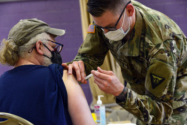 美国一名国民警卫护士，周三为一名男子注射莫德纳疫苗。（美联社）