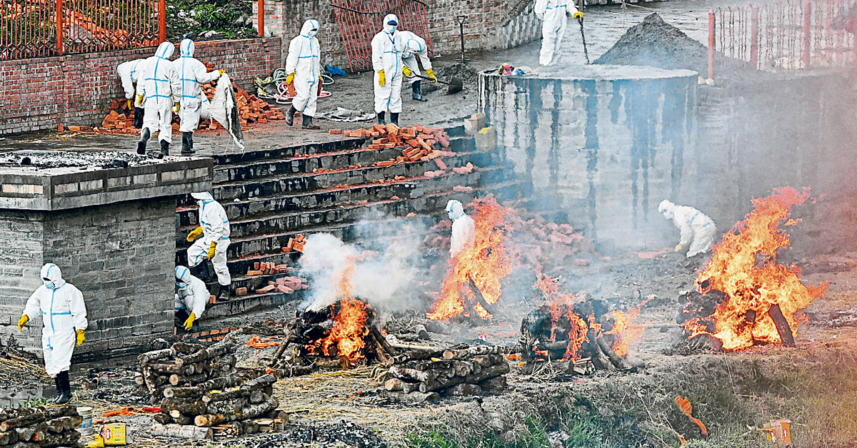 尼泊尔加德曼都一处火葬场的工作人员,周四将患者遗体集体火化。(法新社)