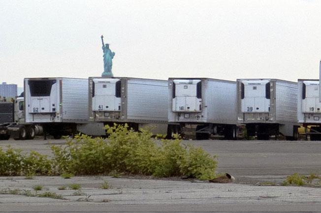 去年5月，在纽约市距离曼哈顿不远的39街附近，停着不少存放遗体的冷藏车。（美联社资料图）