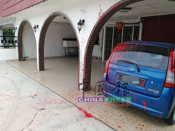 泊在庭院的轿车及墙面被漆色染红。