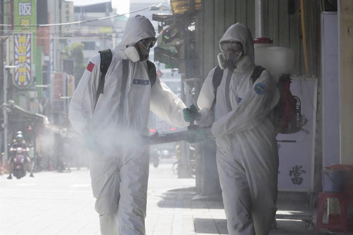 台北市万华地区疫情严峻，北市环保局16日在陆军第6军团33化学兵群支援下，动员逾百人启动第2波万华全区地毯式大消毒，以两人一组的化学兵仔细清消。（中时新闻网）