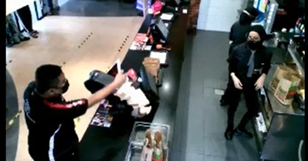 男子打翻柜台上的收银机等物品。