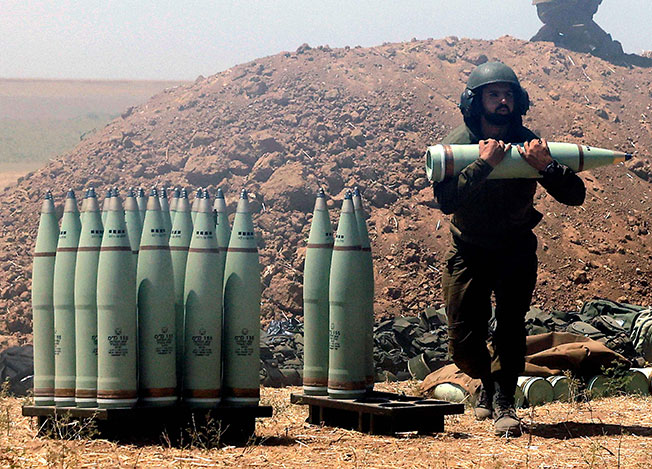 在巴勒斯坦边界，以军士兵19日搬运炮弹，准备对加萨发动空袭。（法新社）