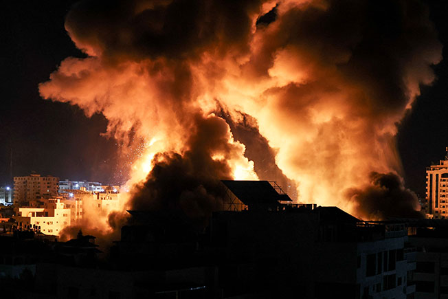 加萨建筑周二凌晨遭以色列火箭弹袭击后，火光冲天。（法新社）