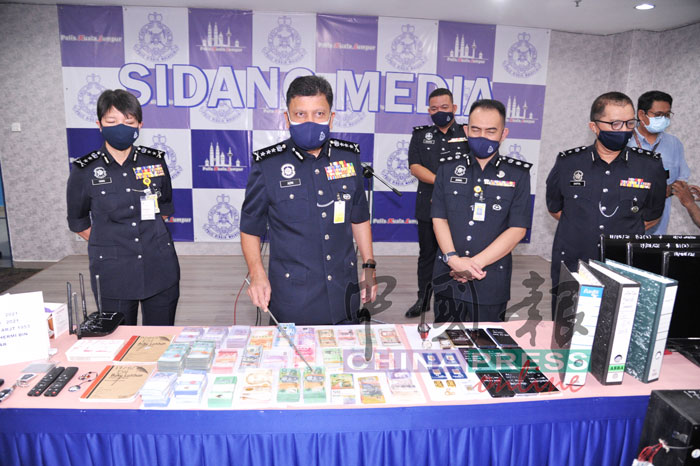 阿兹米（左2）展示警方起获的现款和金条等。左起杨丽珠、再纳助理总监及赛夫高级助理总监。