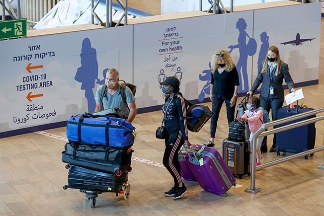 以色列试验性允许特定国家的小团旅客入境，图为周日抵达特拉维夫本古里安机场的旅客。（法新社）