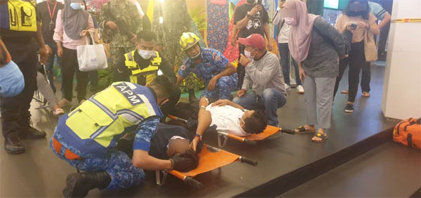 消拯员安抚在担架上的伤者，并称会尽快将他们送院救医。