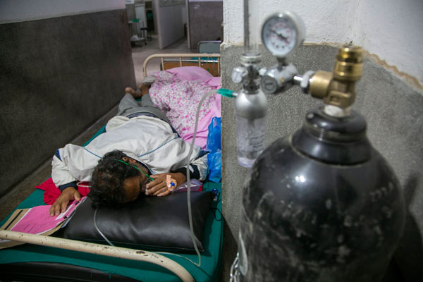一名新冠患者在尼泊尔医院病床上吸氧。（资料图）