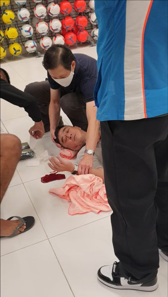 郭方荣倒在地上，鼻孔开始血流不止，公众见状上前帮忙用毛巾垫高他的头部止血。（受访者提供）