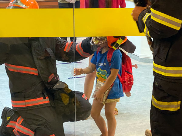 民防人员进行救援时，先让小男孩戴上安全头盔，以防万一。（读者提供）