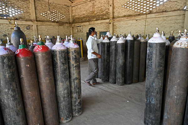 印度一家氧气工厂员工正检查氧气筒。（法新社）