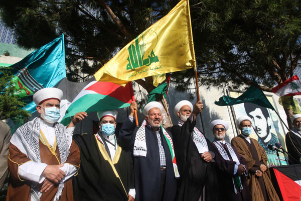 黎巴嫩南部毗邻以色列边境的城镇卡法尔基拉的民众，14日举行反以色列示威，高举巴勒斯坦和真主党（Hezbollah）的旗帜。（法新社）