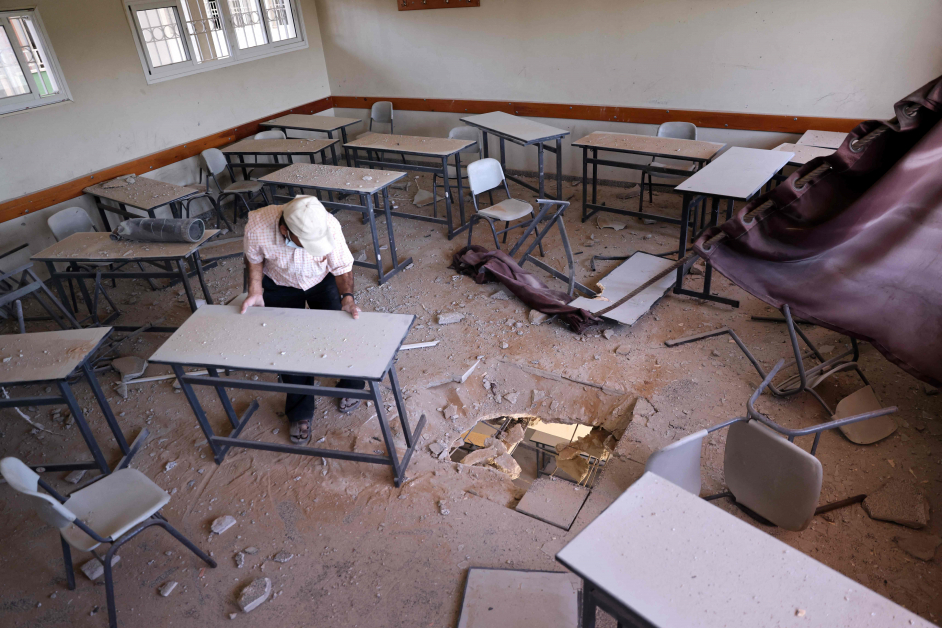 以色列也炸毁加萨一所学校，图为一名巴勒斯坦男子27日到课室试图重排桌椅。（法新社）