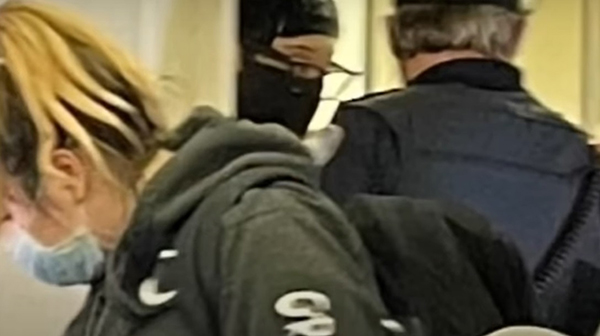 对空姐动粗的基诺内斯（左）被警员带离机舱。