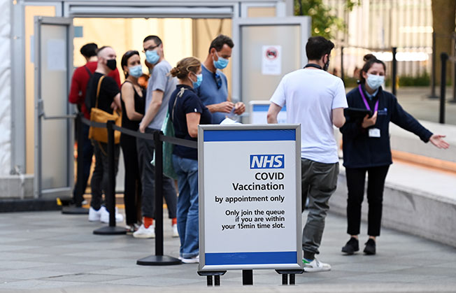 伦敦民众周二排队进入疫苗接种中心。（欧新社）