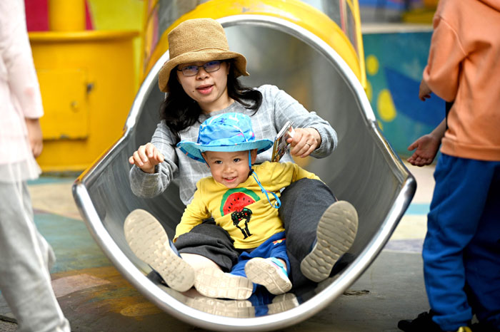 5月11日，一名妈妈在北京五棵松购物区和孩子一同玩耍，场面温馨。（法新社）