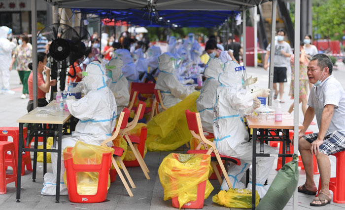 医务人员上周六在广州荔湾区白鹤洞街广钢新城进行核酸检测工作。（新华社）