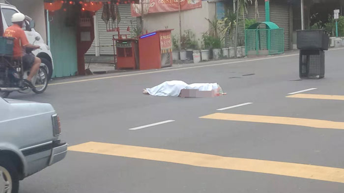 男子在路过马路时，遭嫌犯车辆撞死，其尸体被盖上白布。