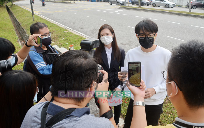 林尚进（右,白衣者）在报案结束后，在警区外召开记者会。