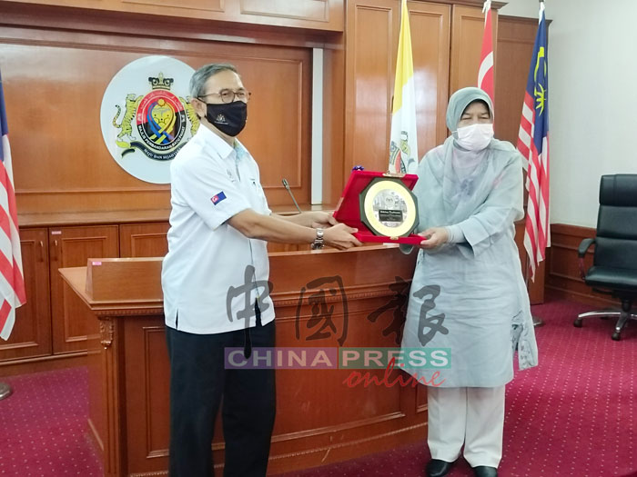 祖莱达（右）从峇株巴辖区国会议员拿督莫哈末拉昔手中接获纪念品。