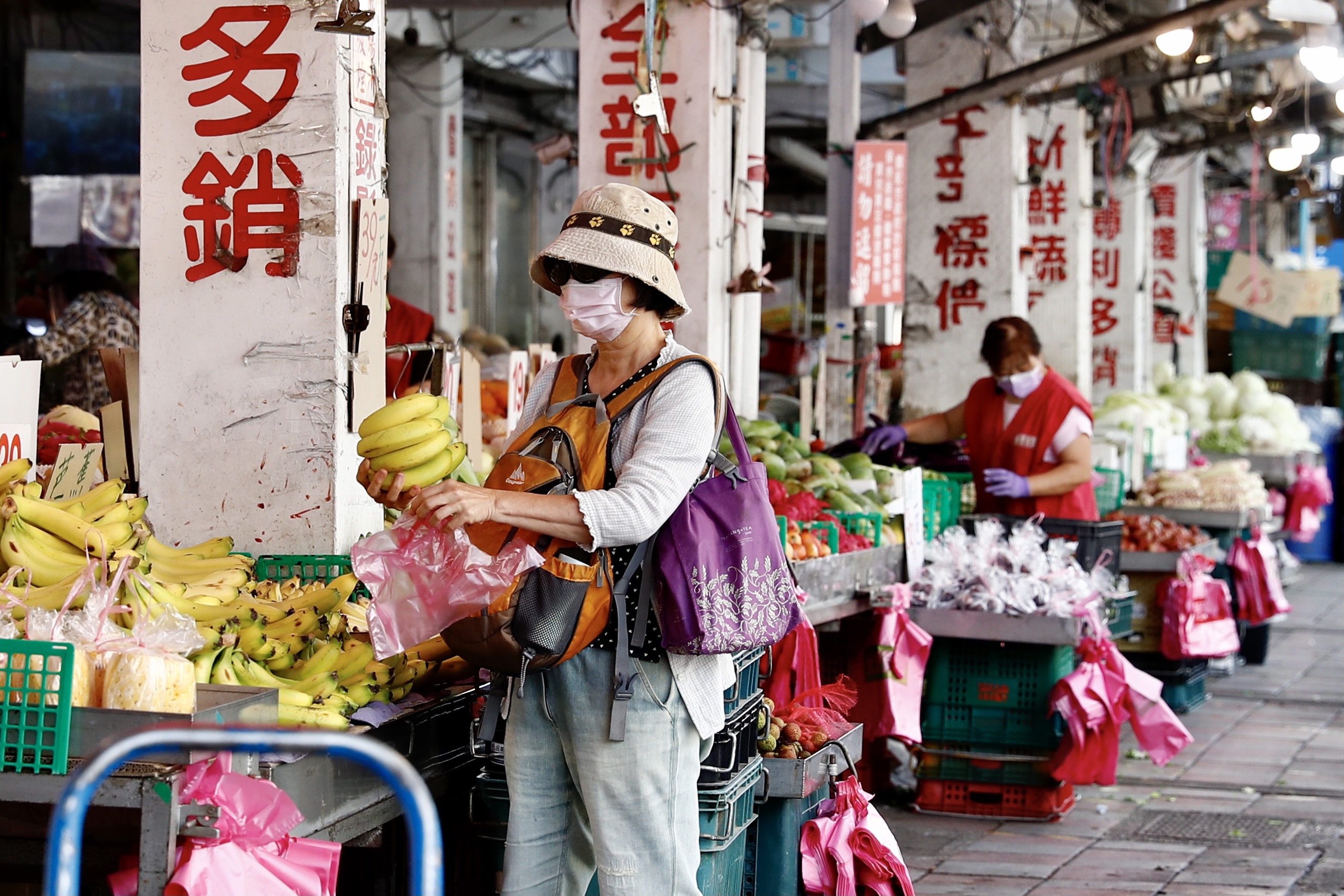 台北妇女周一戴口罩外出买菜。（欧新社）