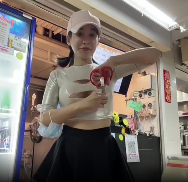 在芳林熟食中心经营啤酒摊位的越南啤酒妹Yum，在视频中用剪刀在上衣剪出三个洞，露出部分胸部后遭网民谴责。（取自面子书）