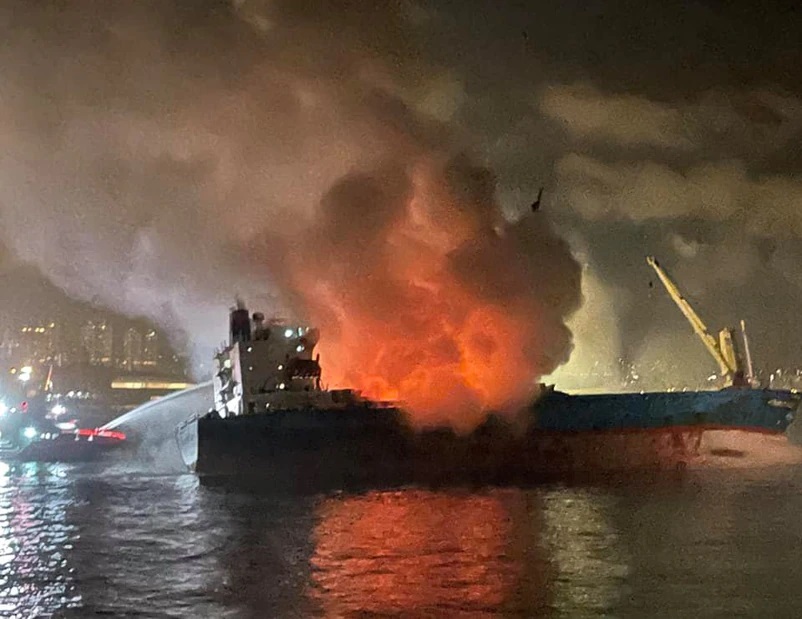 大批消防员对趸船喷水救火。