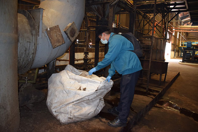 环境局官员到一间工厂进行检查 。