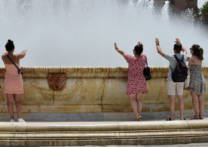 西班牙有民众7月10日，围绕在安达鲁西亚自治区塞维利亚市一座喷泉降温。（法新社）